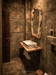 a bathroom with a sink and a mirror at Rrenjet - The Roots in Ersekë
