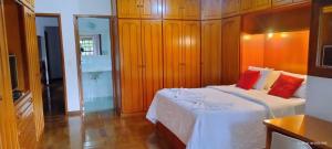 a bedroom with a bed with white sheets and red pillows at Pousada Viking Penedo in Penedo