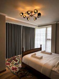 a bedroom with a large bed and a chandelier at Rrenjet - The Roots in Ersekë