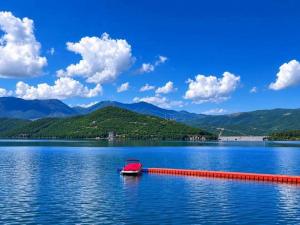 a red boat in the middle of a large lake at Lake of Diber in Debar +9 photos