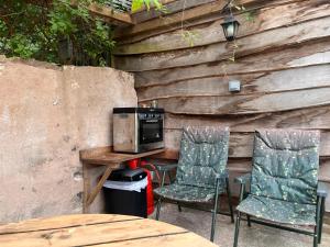 a patio with two chairs and a table with a microwave at Oakdean Cottage Yurt in Blakeney