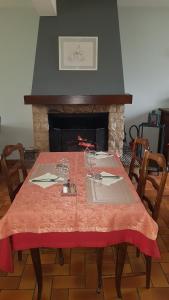 a table with a red table cloth and a fireplace at 24h sur24 in Foissac