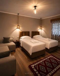 a hotel room with two beds and a couch at Rrenjet - The Roots in Ersekë