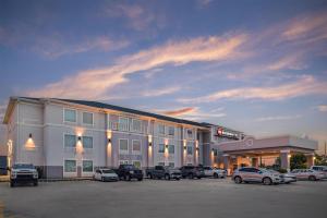 a large building with cars parked in a parking lot at Best Western Plus Chalmette Hotel in Chalmette