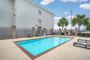 a swimming pool in front of a building at Best Western Plus Chalmette Hotel in Chalmette