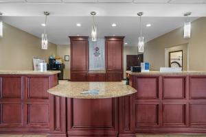a large kitchen with wooden cabinets and a counter top at Best Western Plus Chalmette Hotel in Chalmette +37 photos
