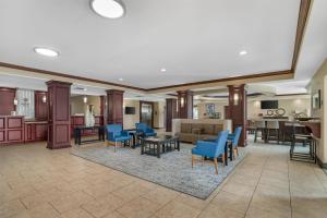 a lobby with blue chairs and a living room at Best Western Plus Chalmette Hotel in Chalmette