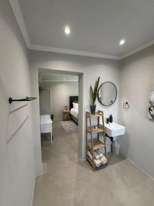 a bathroom with a sink and a mirror at McCrae's Garden Suite in Malmesbury +3 photos