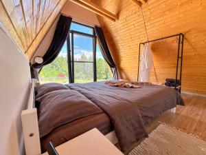 a bed in a room with a large window at Cabana Luminis in Râşnov