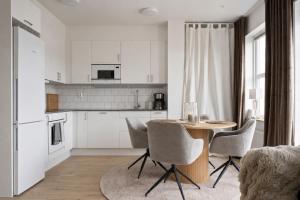 a kitchen with white cabinets and a table and chairs at Luxurious apartment in central Grebbestad! in Grebbestad