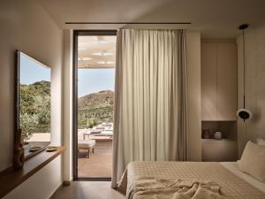 a bedroom with a bed and a sliding glass door at Villa Zeta by Villa Select in Kalamaki