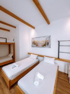 two beds in a room with white walls and wooden floors at il Centro in Ios Chora