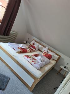 a bedroom with two beds with red flowers on them at Pension und Restaurant La Casa in Undeloh