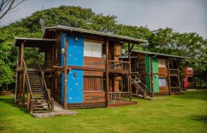 a large wooden house with stairs in the grass at Posada La Solana in El Cadillal