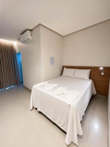 a bedroom with a large white bed with white sheets at Lopo Palace in Porangatu