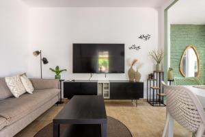 a living room with a couch and a flat screen tv at Villa 65 in Ilaniyya