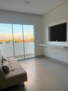 a living room with a couch and a flat screen tv at Lopo Palace in Porangatu +12 photos