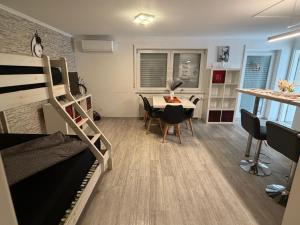a dorm room with a bunk bed and a table at 2 Zimmer Apartment am Europapark - auf Wunsch klimatisiert für 10,-Aufpreis pro Nacht in Rust
