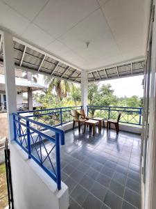 a balcony with chairs and tables on a house at Palm Cozy Villa 4 in Pasauran