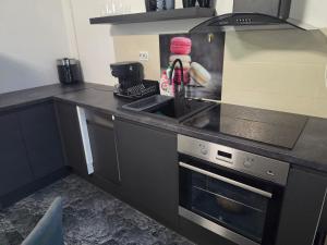 a kitchen with a sink and a stove at Apartament Eduard in Techirghiol +6 photos