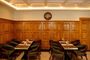 a dining room with two tables and a clock on the wall at Alasha Retreat in Srinagar
