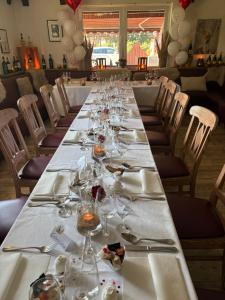 a long table with wine glasses on it at Pension und Restaurant La Casa in Undeloh +4 photos