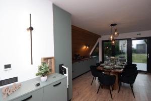 a kitchen and dining room with a table and chairs at Cabana Casa Luca in Rănuşa