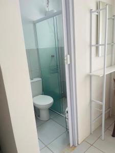 a bathroom with a toilet and a glass shower at Pousada Coral in Osório