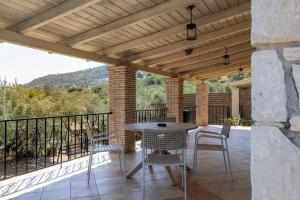 a patio with a table and chairs on a balcony at Villa Helona in Keri