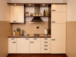 a kitchen with white cabinets and a sink at Beachfront Pearl in Rafailovici