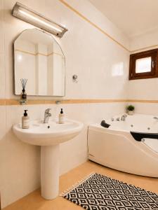 a bathroom with a sink and a bath tub at Beachfront Pearl in Rafailovici +8 photos