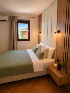 a bedroom with a large bed with a window at Beachfront Pearl in Rafailovici