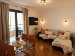 a living room with a couch and a table at Beachfront Pearl in Rafailovici
