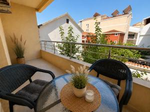 a balcony with two chairs and a glass table at Beachfront Pearl in Rafailovici
