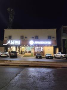 a building with cars parked in a parking lot at night at الارجان للشقق المفروشة in Al Nairyah
