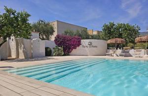 a swimming pool with chairs and a building at Hotel Residence Torre Del Porto in Mattinata