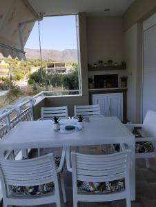 a white table and chairs in a room with a window at Villa Evdokia in Limenaria