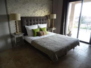 a bedroom with a large bed with green pillows at Maison du Lac in Les Angles Gard
