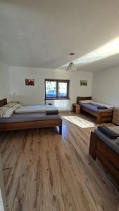 a large room with two beds and wooden floors at Chata Chotár Nová Baňa in Veľká Lehota