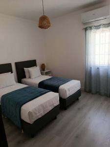 a bedroom with two beds and a window at Casa 56 in Sardoal +25 photos