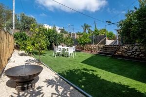 a small garden with a table and chairs on the grass at Villa 65 in Ilaniyya