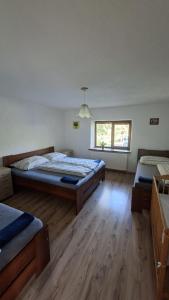 a bedroom with two beds and a window at Chata Chotár Nová Baňa in Veľká Lehota