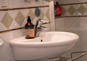 a bottle of alcohol sitting on top of a bathroom sink at Korbzimmer Apartment in Lichtenfels +13 photos