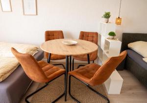 a dining room with a table and four chairs at Korbzimmer Apartment in Lichtenfels