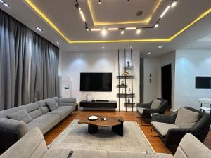 a living room with a couch and a tv at DOD Residence I Cozy 3BR with Fast Wifi in Ikuata