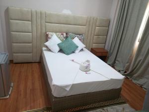a bed with white sheets and pillows in a room at Hotel Ultima Estação in Tete