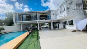 a house with a swimming pool and a patio at Hotel Ultima Estação in Tete