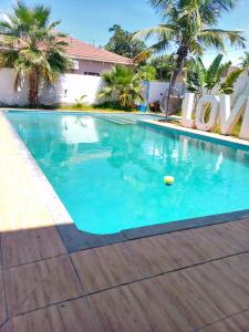a swimming pool with blue water and palm trees at Hotel Ultima Estação in Tete