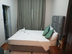 a bedroom with a bed with green pillows on it at Hotel Ultima Estação in Tete