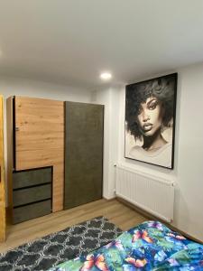 a bedroom with a bed and a large painting on the wall at Apartmans Lars in Rečica ob Savinji